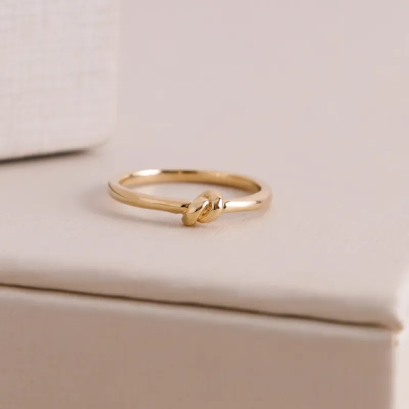 ANEL LISO COM NÓ NO CENTRO BANHADO A OURO 18K