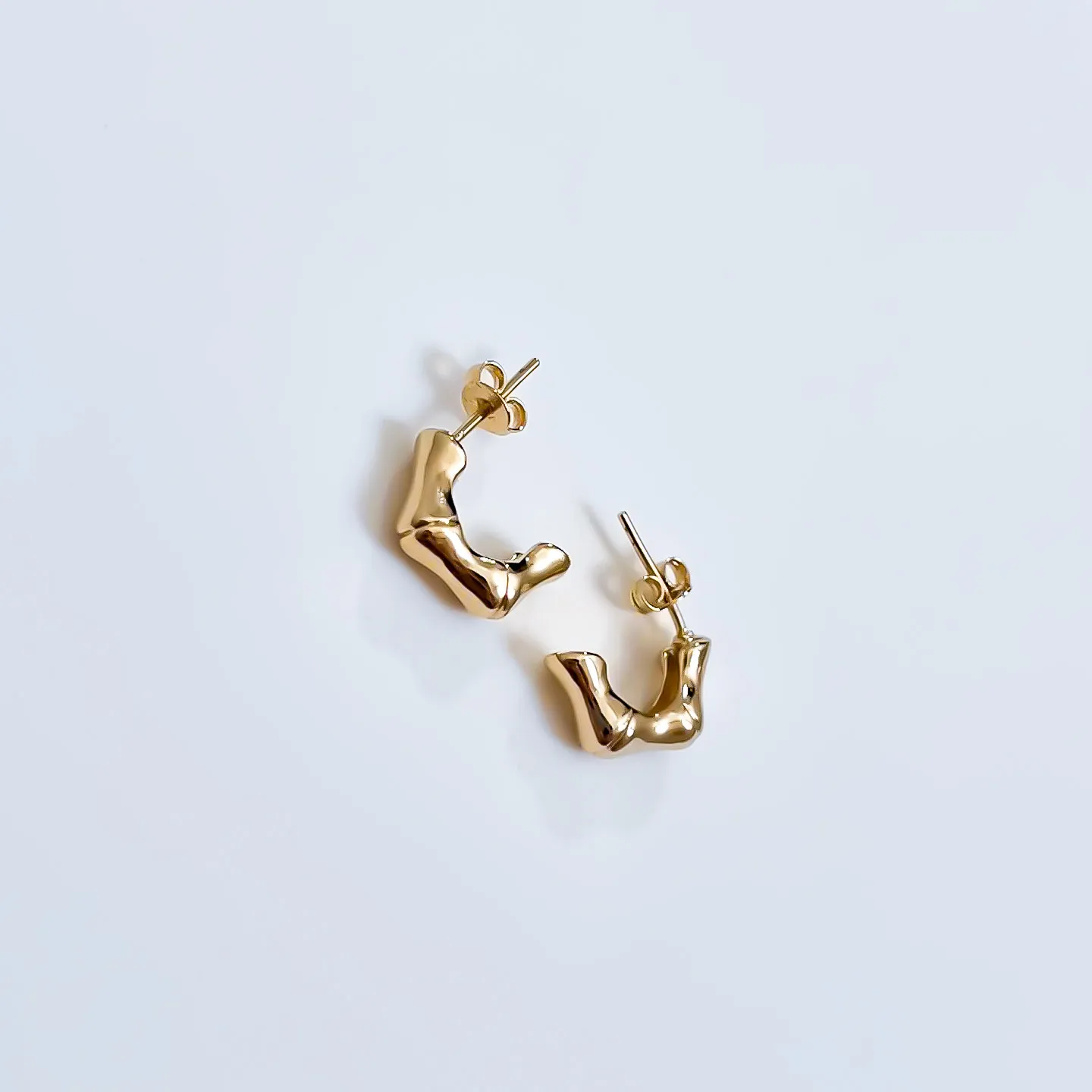 Brinco argola formato orgânico e estrutura irregular fluida banhado a ouro 18K